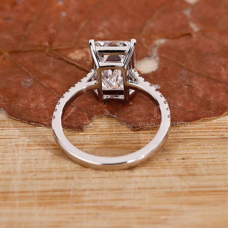 white gold ring in gold emerald cut engagement style.