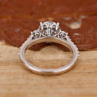 White gold ring with 3 stone round diamonds and milgrain finish.