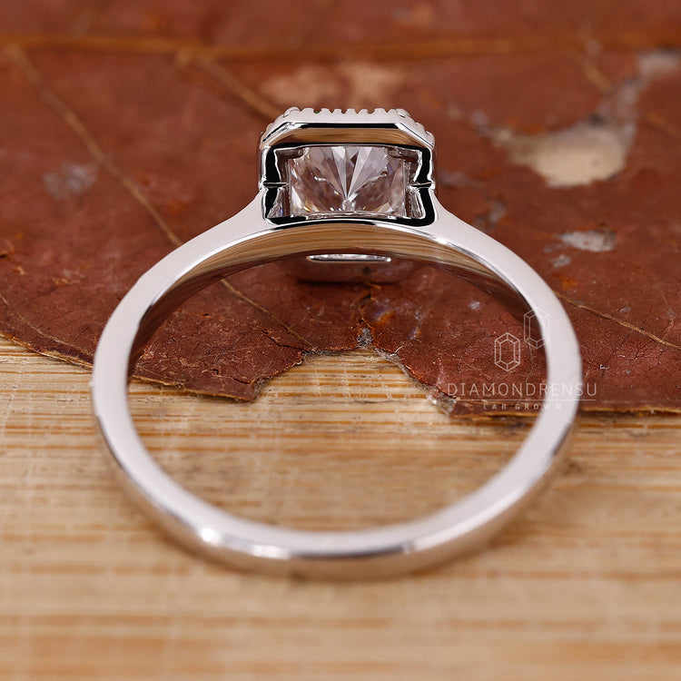 Buy engagement ring online with radiant cut diamond and emerald accents in white gold.