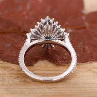 Prong setting ring with marquise diamond and round halo in white gold.