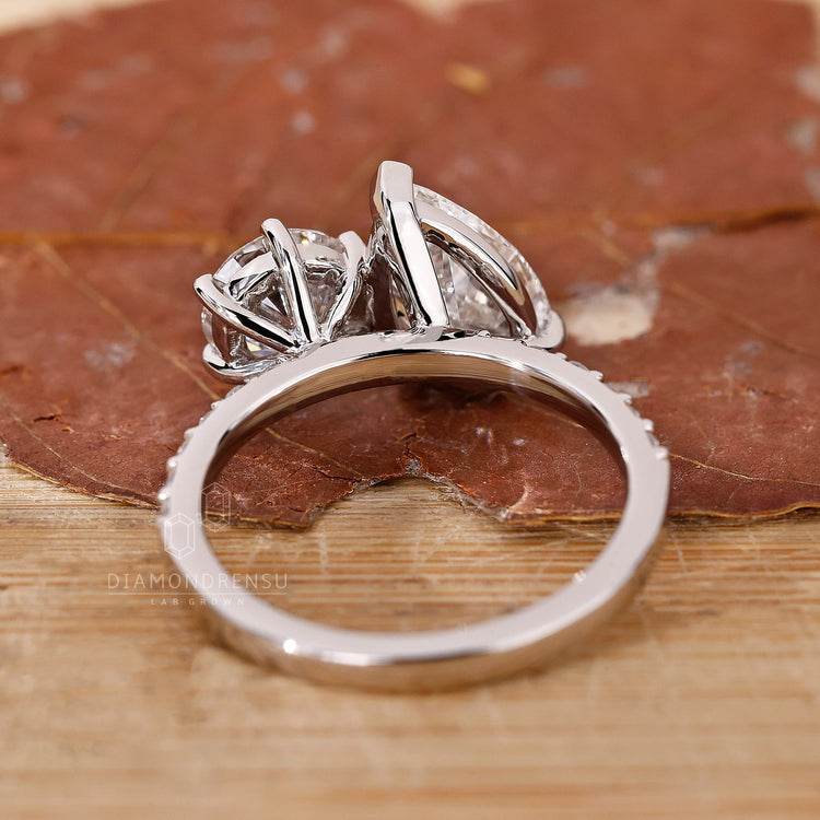 White gold ring with pear and round diamonds in a two stone design.