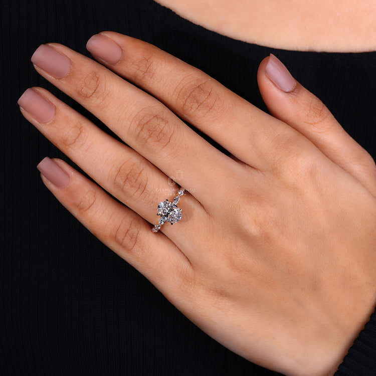 Rose gold oval engagement ring with round cut accents.