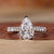 Close-up of a pear shaped diamond ring with pave diamond accents Close-up of a pear shaped diamond ring with pave diamond accents