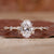 Hidden halo oval engagement ring with yellow gold band and claw prongs, showcasing a lab grown diamond. Hidden halo oval engagement ring with yellow gold band and claw prongs, showcasing a lab grown diamond.