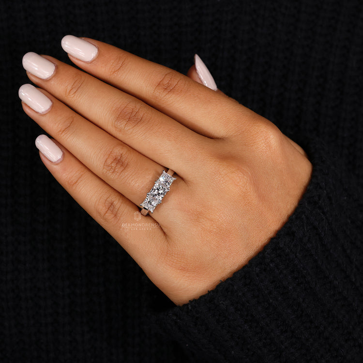 Handmade ring featuring three stones with a princess cut and prong setting.
