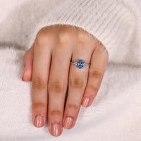 Marquise and round side stone in blue diamond ring.