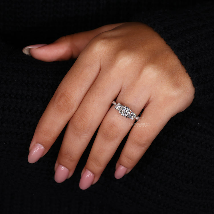 Round prong setting in 3 stone diamond engagement ring.
