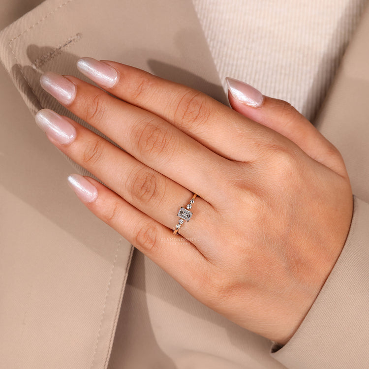 Yellow Gold Ring with emerald cut and round side diamonds.