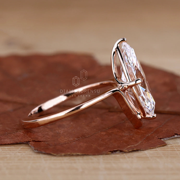 Unique engagement ring with a marquise diamond and compass prong design.