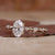 Handmade ring with hidden halo, oval diamond, and claw prongs, displayed on a soft velvet box.