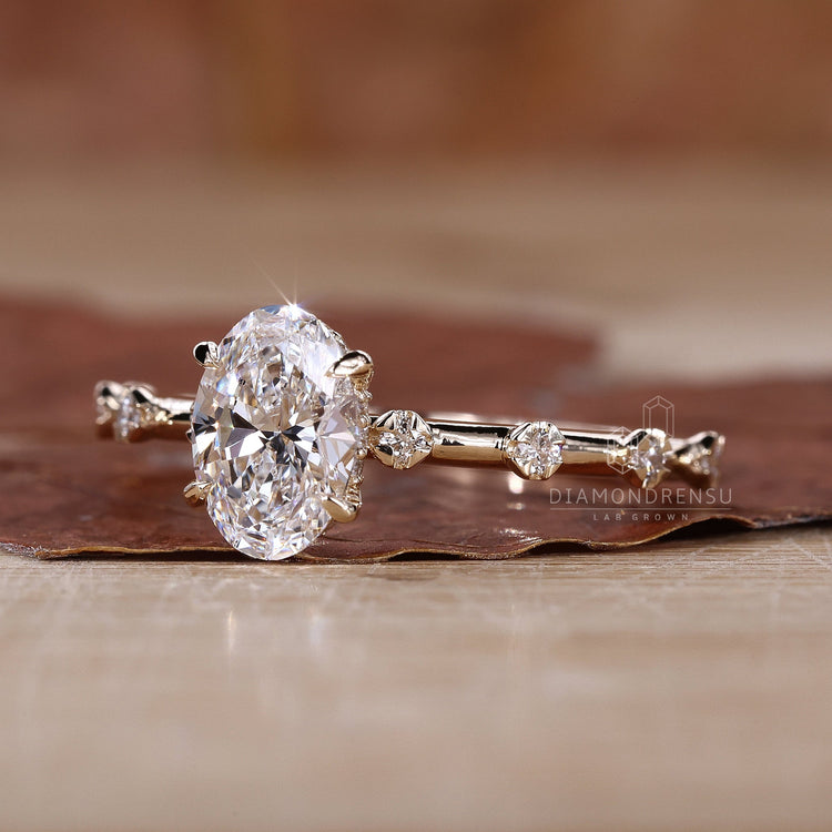 Handmade ring with hidden halo, oval diamond, and claw prongs, displayed on a soft velvet box.