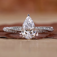 Close-up of a pear shaped diamond ring featuring twisted diamond pave