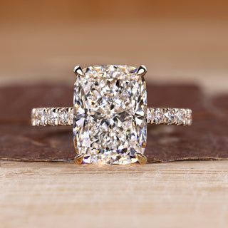 Elongated cushion ring with round diamond pave band.