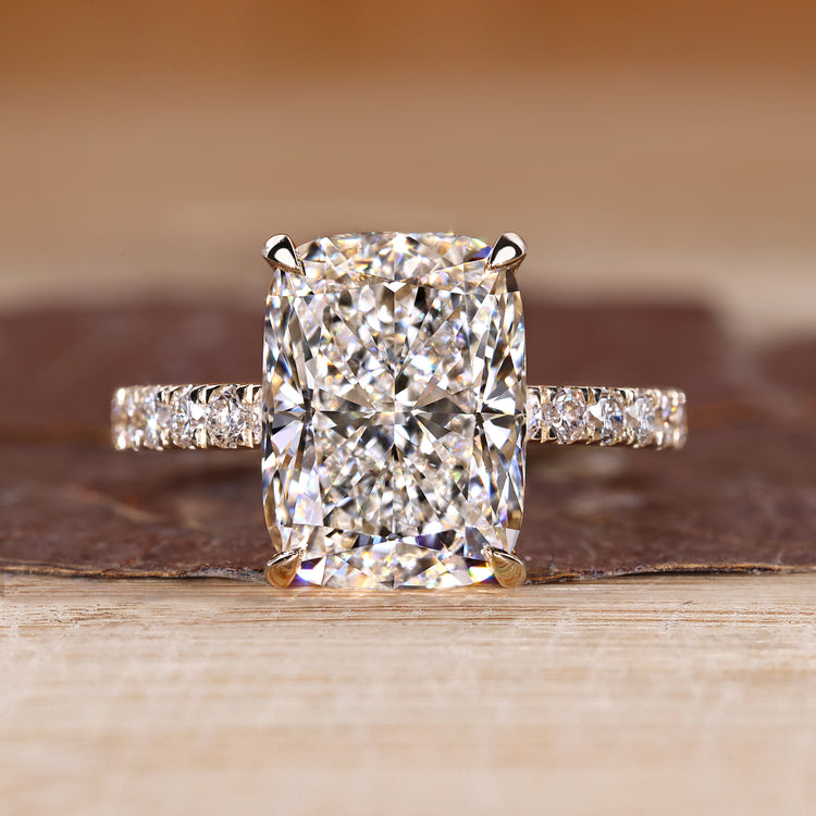 Elongated cushion ring with round diamond pave band.
