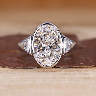 Oval cut diamond ring with half moon side stone.