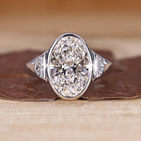 Oval cut diamond ring with half moon side stone.