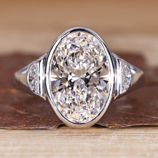 Oval cut diamond ring with half moon side stone.