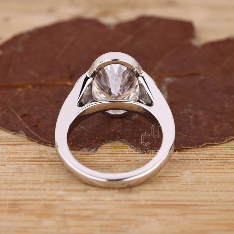 Half moon side stone oval cut diamond ring.