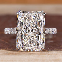 Radiant cut diamond ring with pave round diamond band.