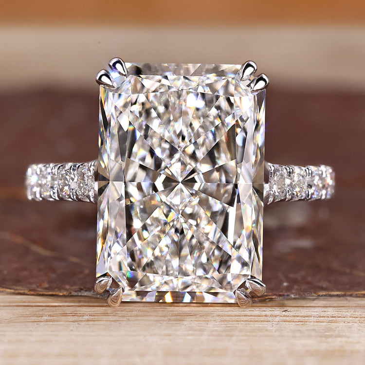 Radiant cut diamond ring with pave round diamond band.