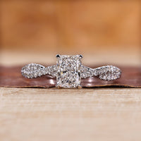 Elongated cushion cut diamond ring with twisted pave band.