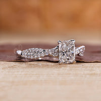 Round cut diamond in elongated cushion cut diamond ring.