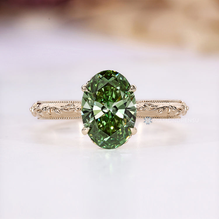 Green oval diamond ring with four claw prongs.