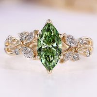 Green diamond ring with round and marquise side stones.