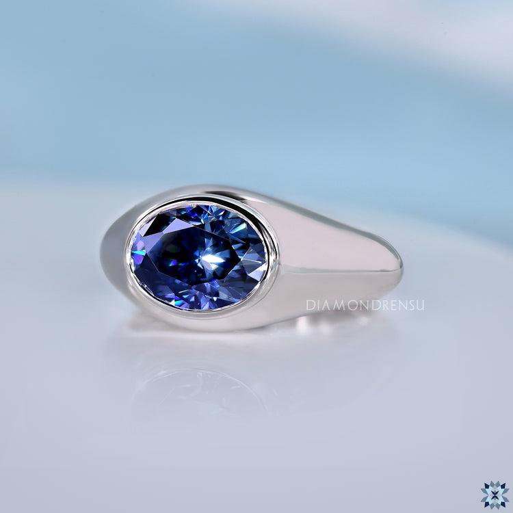 Gypsy set oval blue moissanite solitaire ring.