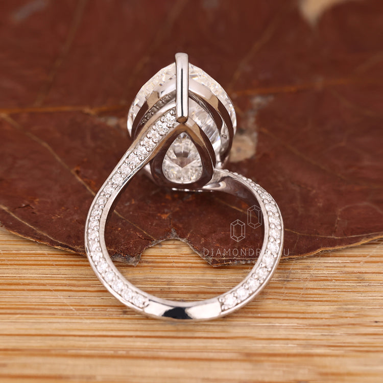 Handmade jewellery pear diamond ring with pave round diamonds.