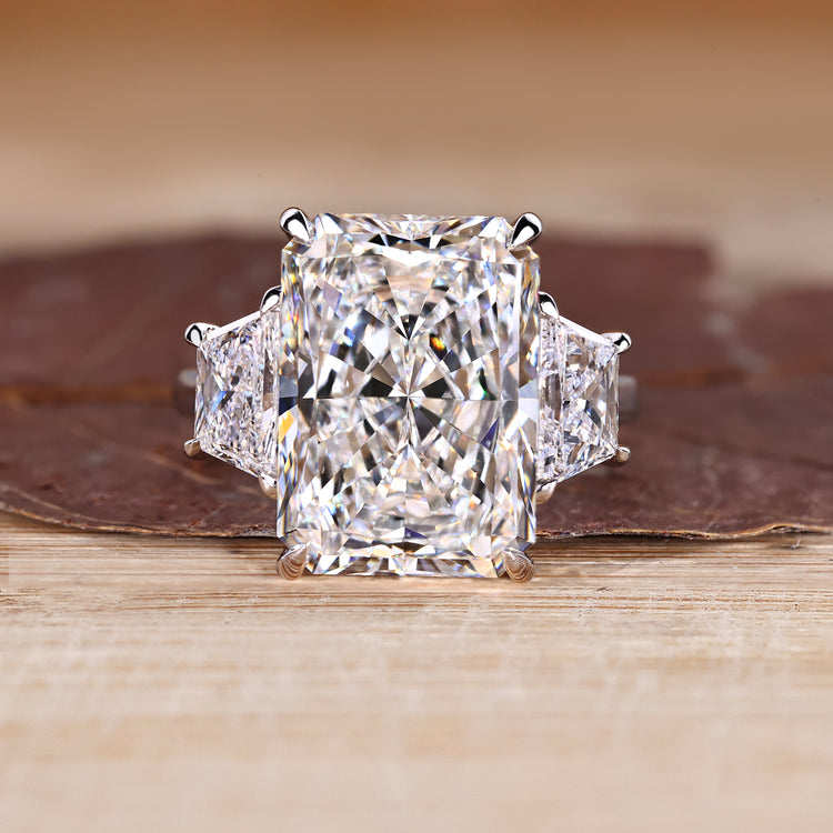 3 stone radiant cut ring with trapezoid side stone and cathedral setting.