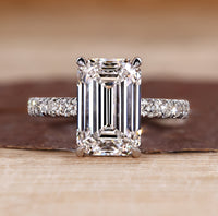 Pave diamond ring with emerald cut centre stone.