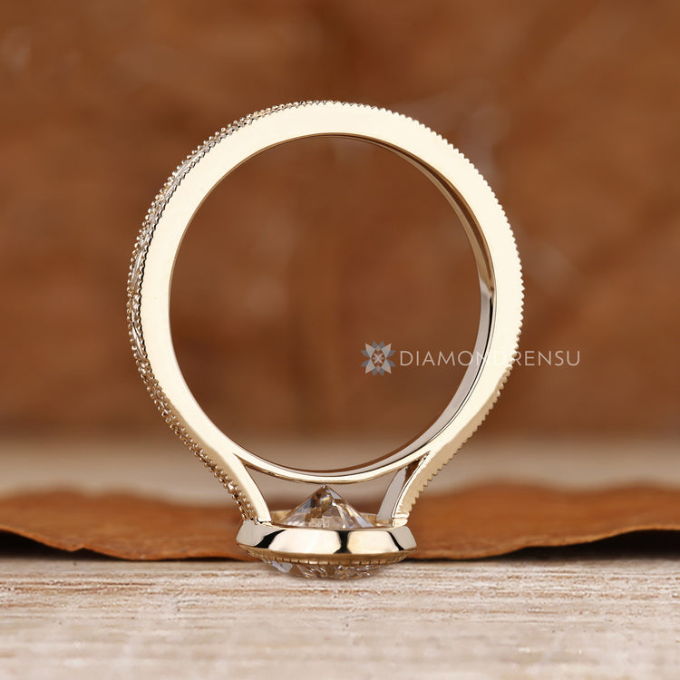 Oval diamond ring with bezel and cathedral setting.