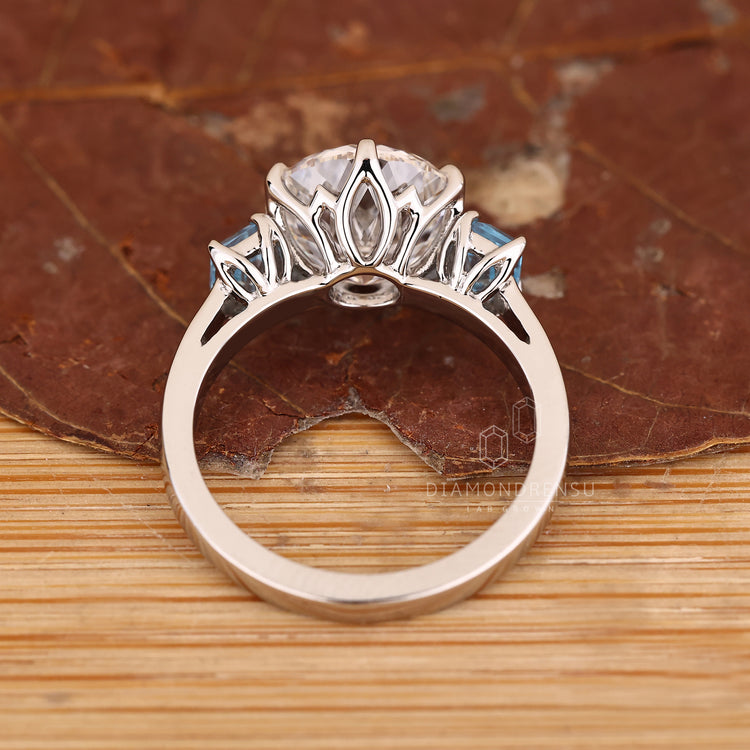 Lab grown diamond ring with emerald side stone accents.