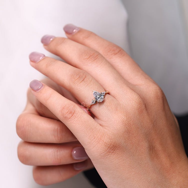 Pear cut ring three stone kite side stones tapered.