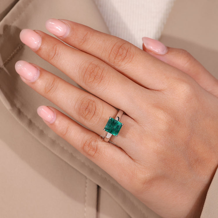 Asscher cut emerald ring four claw prong setting.