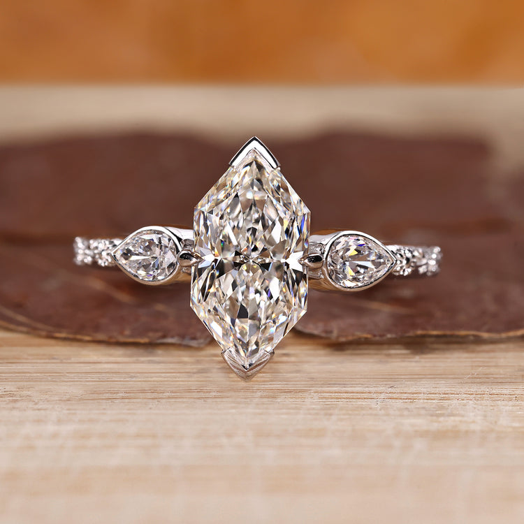 Dutch marquise ring with pear cut side stones in three stone style.