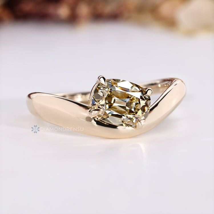 Cushion diamond ring with four claw prong setting.