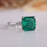 Asscher emerald ring four tab prong hidden halo style.