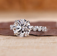 Blue oval diamond ring with heart shape side stones.