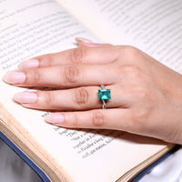 Emerald gemstone ring with twisted shank design.