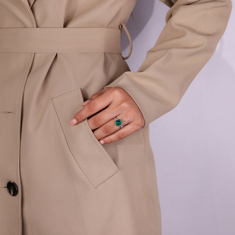 Twisted shank emerald gemstone diamond ring.