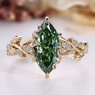 Marquise diamond ring with green diamond accent.