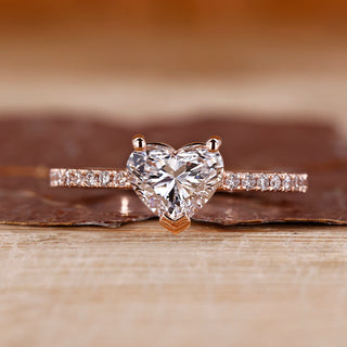 Heart cut diamond ring with round cut pave setting.