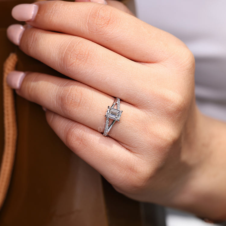 Emerald cut ring pave band round diamonds four claw set.