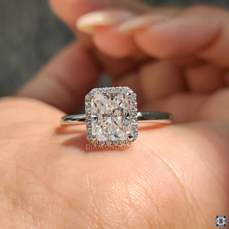White gold ring with a radiant cut stone in a traditional halo setting