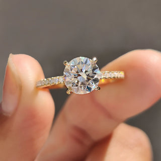 Round pave engagement ring in yellow gold with a delicate claw prong ring setting.