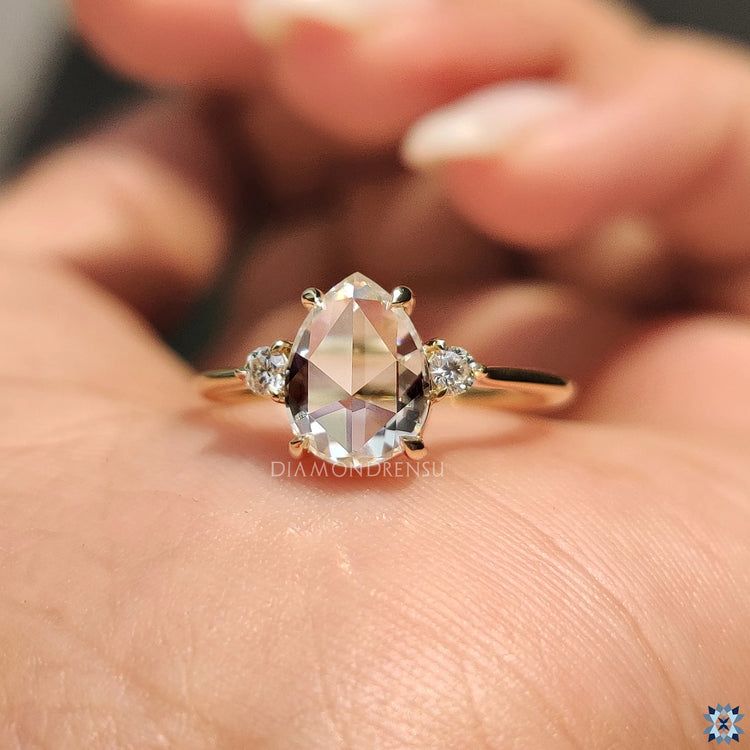 Handmade Ring featuring a unique pear rose cut design with round side stones in a claw prong setting.