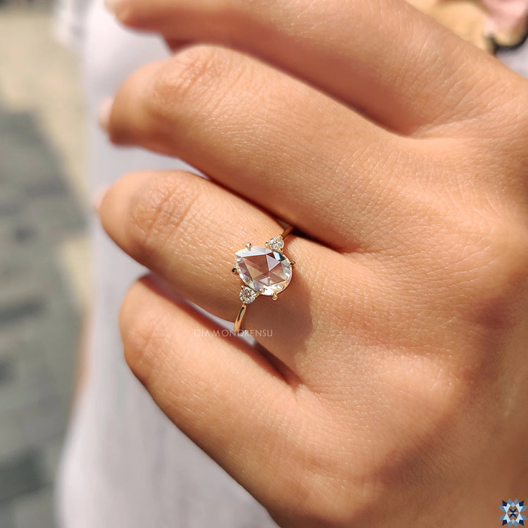 Round Side Stone Engagement Ring in yellow gold with a handmade claw prong setting.