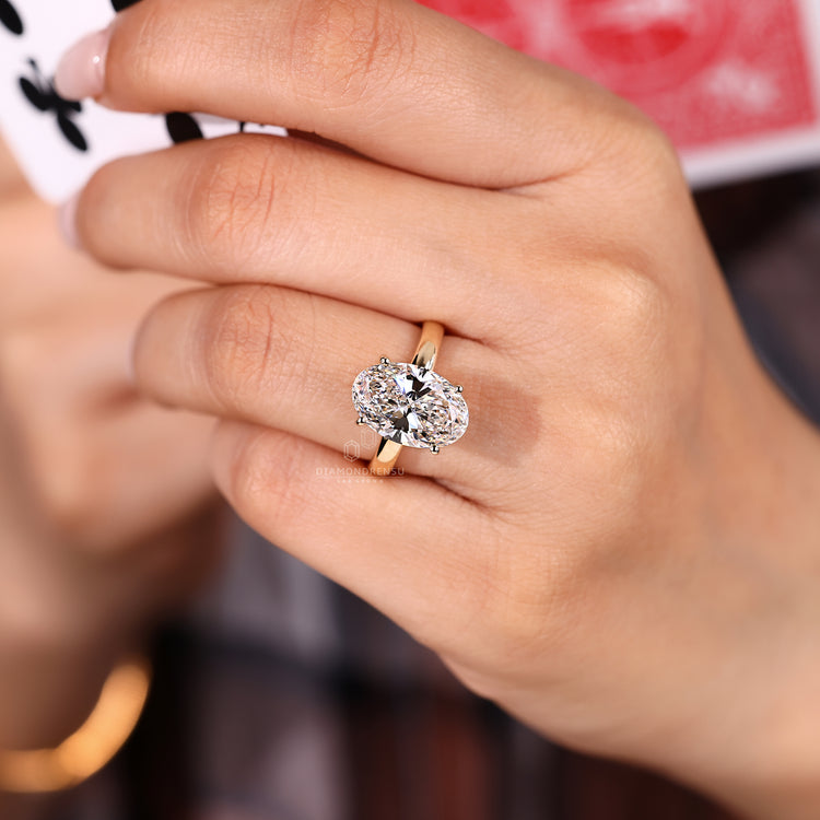 Hidden halo round diamond ring with oval centre stone.